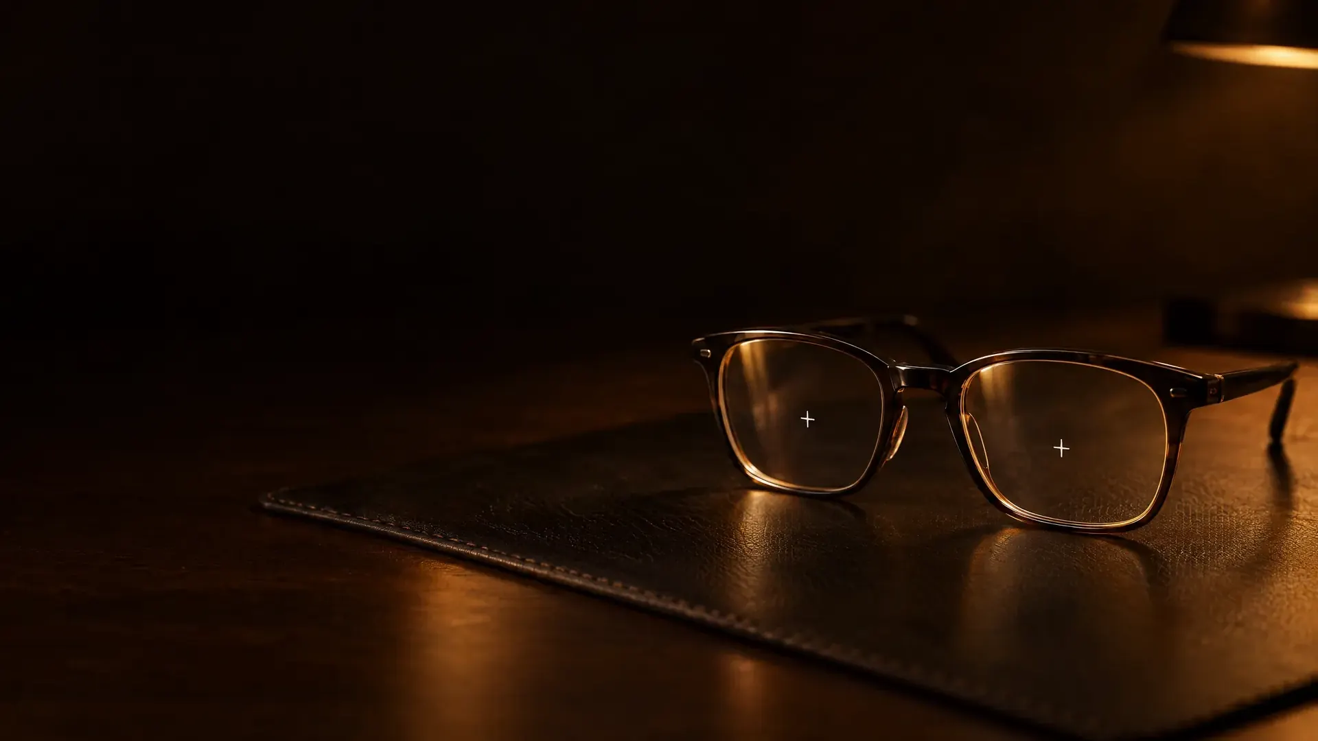 A frame with clear demonstration lenses on a leather fitting mat, a small fitting cross marked on each lens.