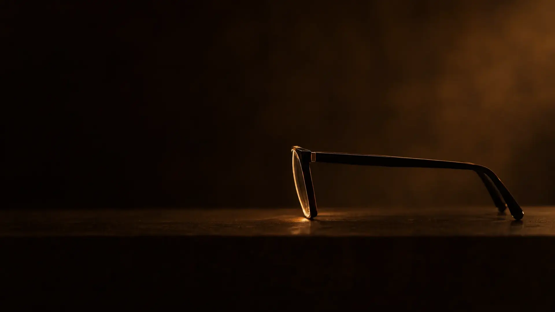 A pair of glasses standing side-on in silhouette, the lens front leaning in at the bottom.