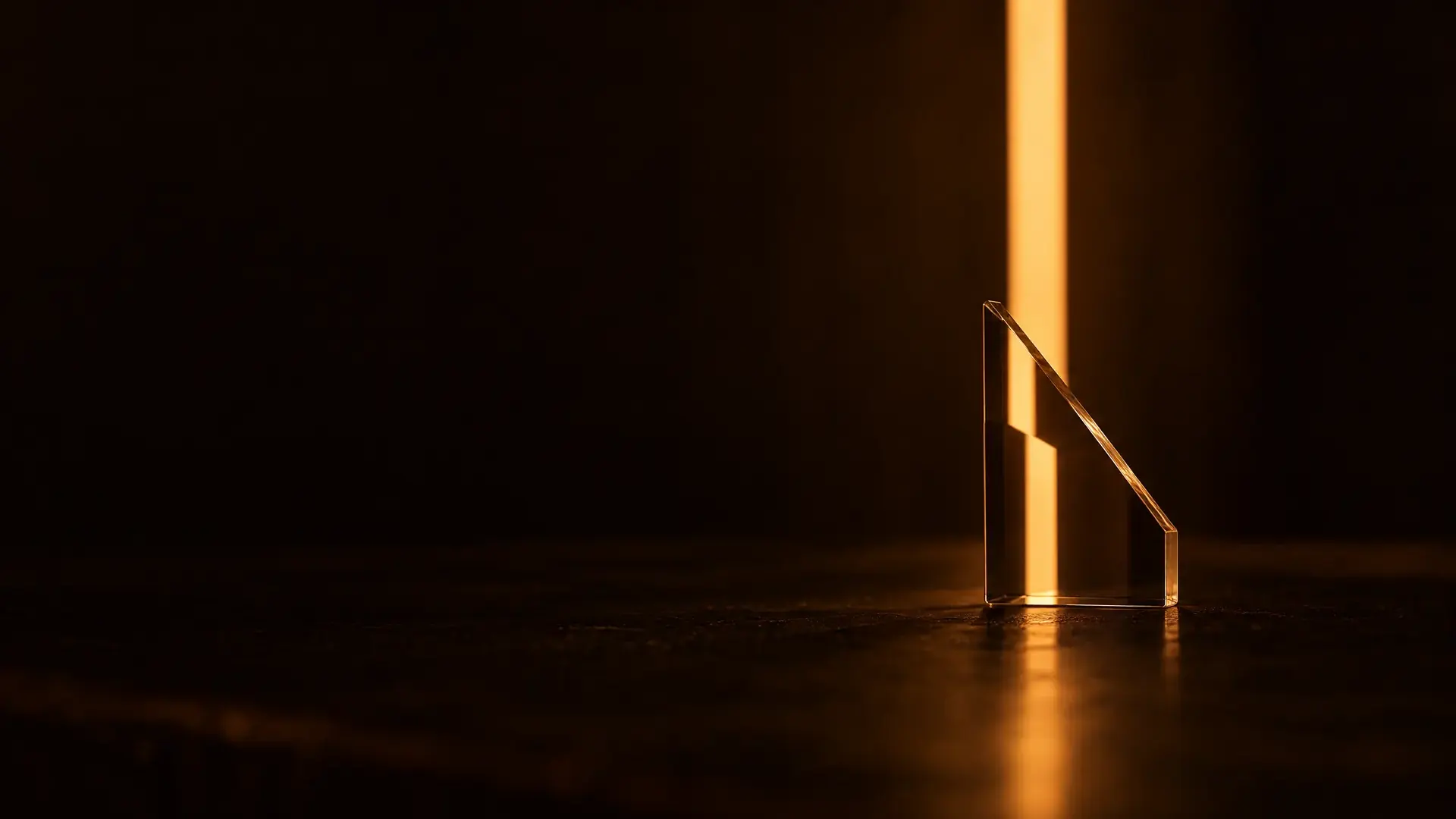 A thin glass wedge in front of a bar of light, the bar seen through it stepped sideways but still sharp.