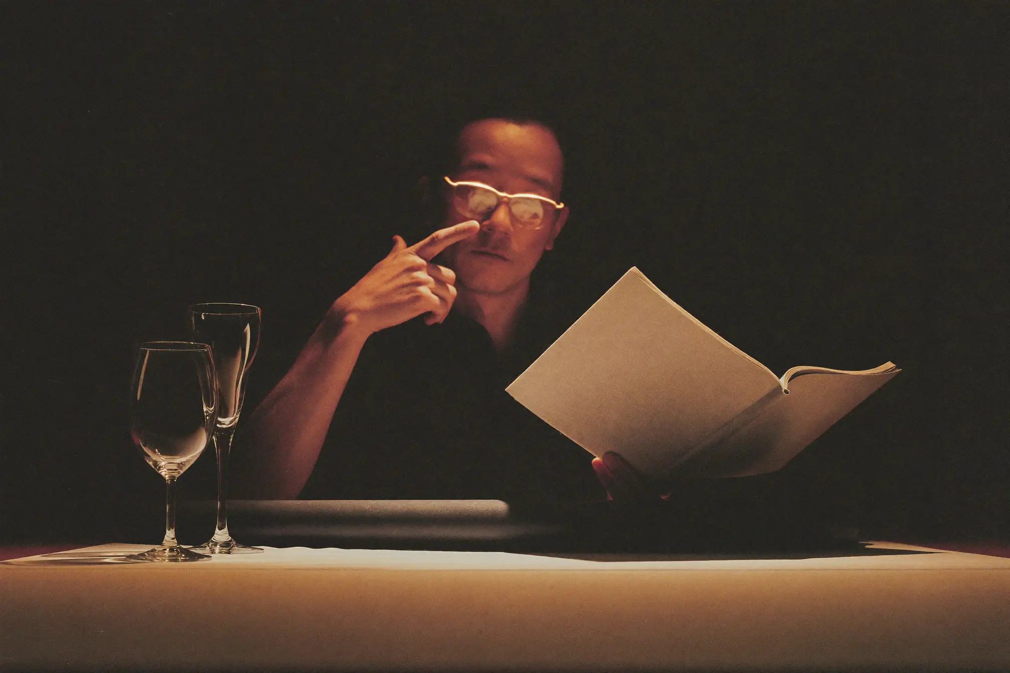 A researcher reading a journal beside glassware.