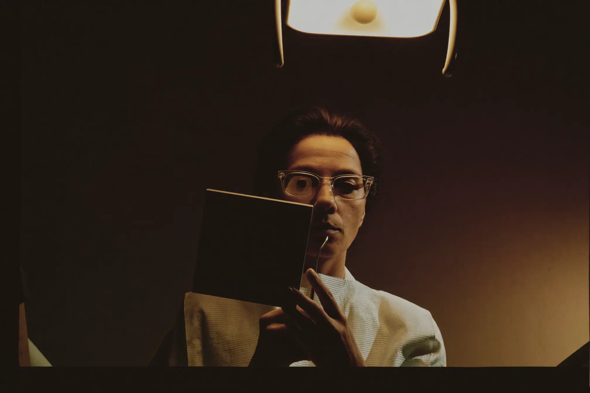 A dentist holding a small dental mirror close.