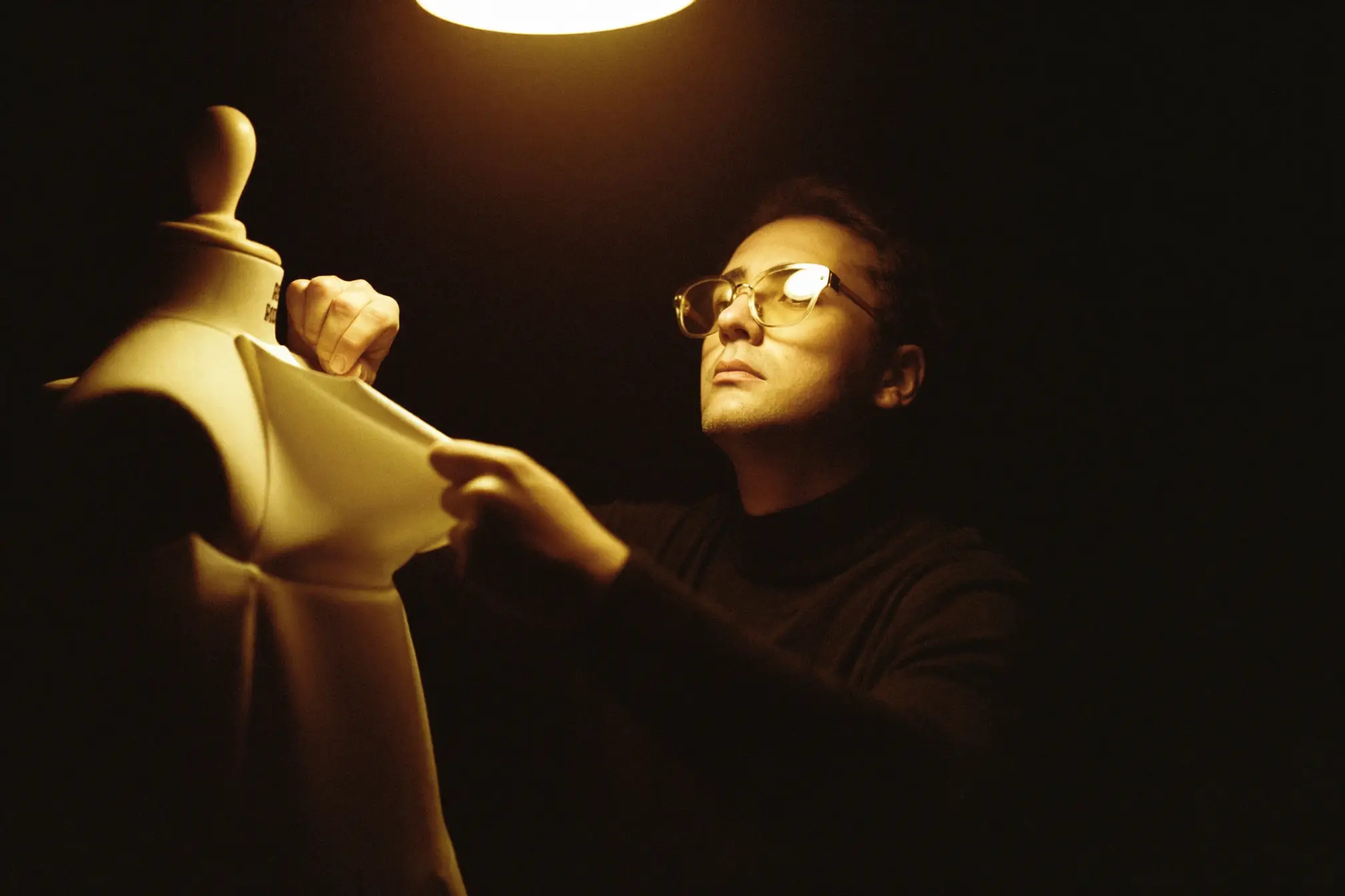 A fashion designer pinning fabric on a dress form.