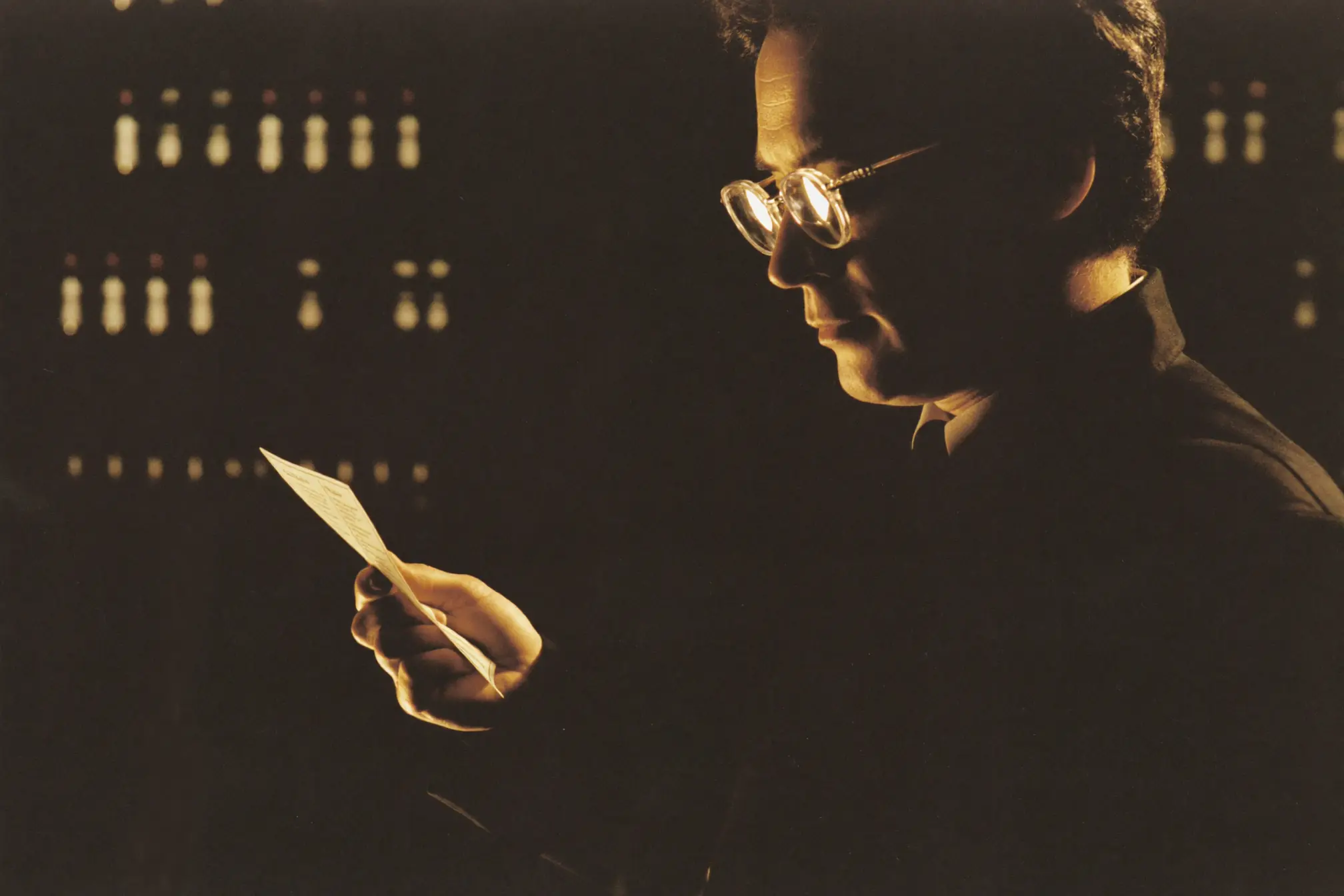 A pharmacist reading a small prescription label.