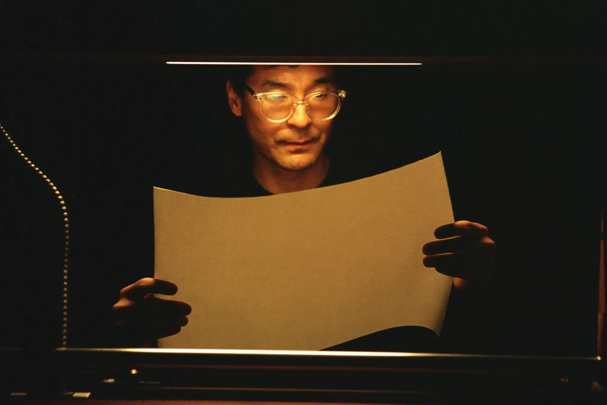 A press operator inspecting a blank printed sheet.