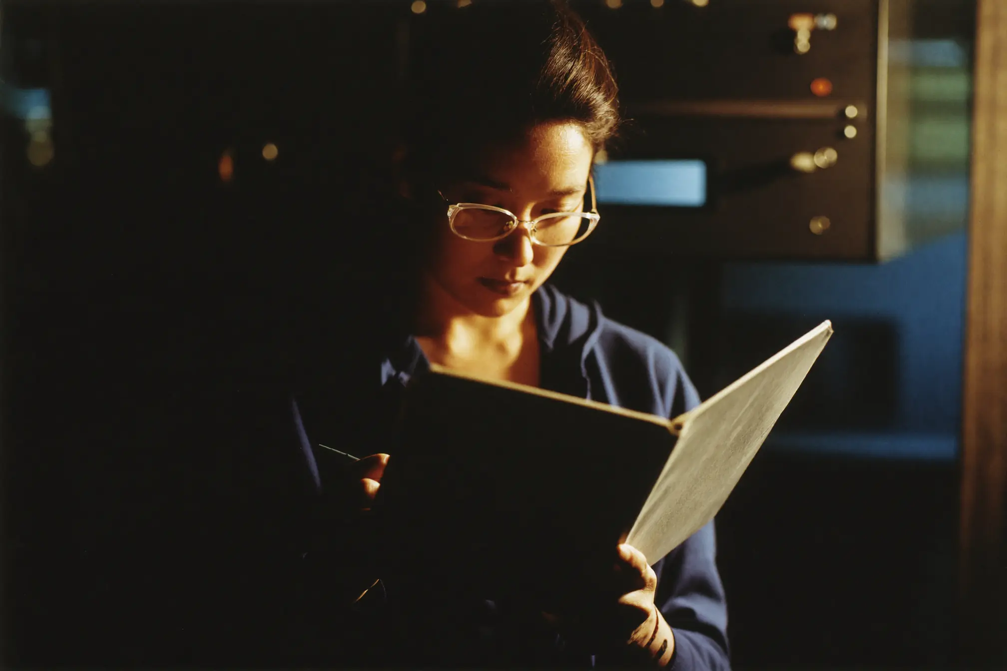 A plant supervisor noting in a blank logbook.