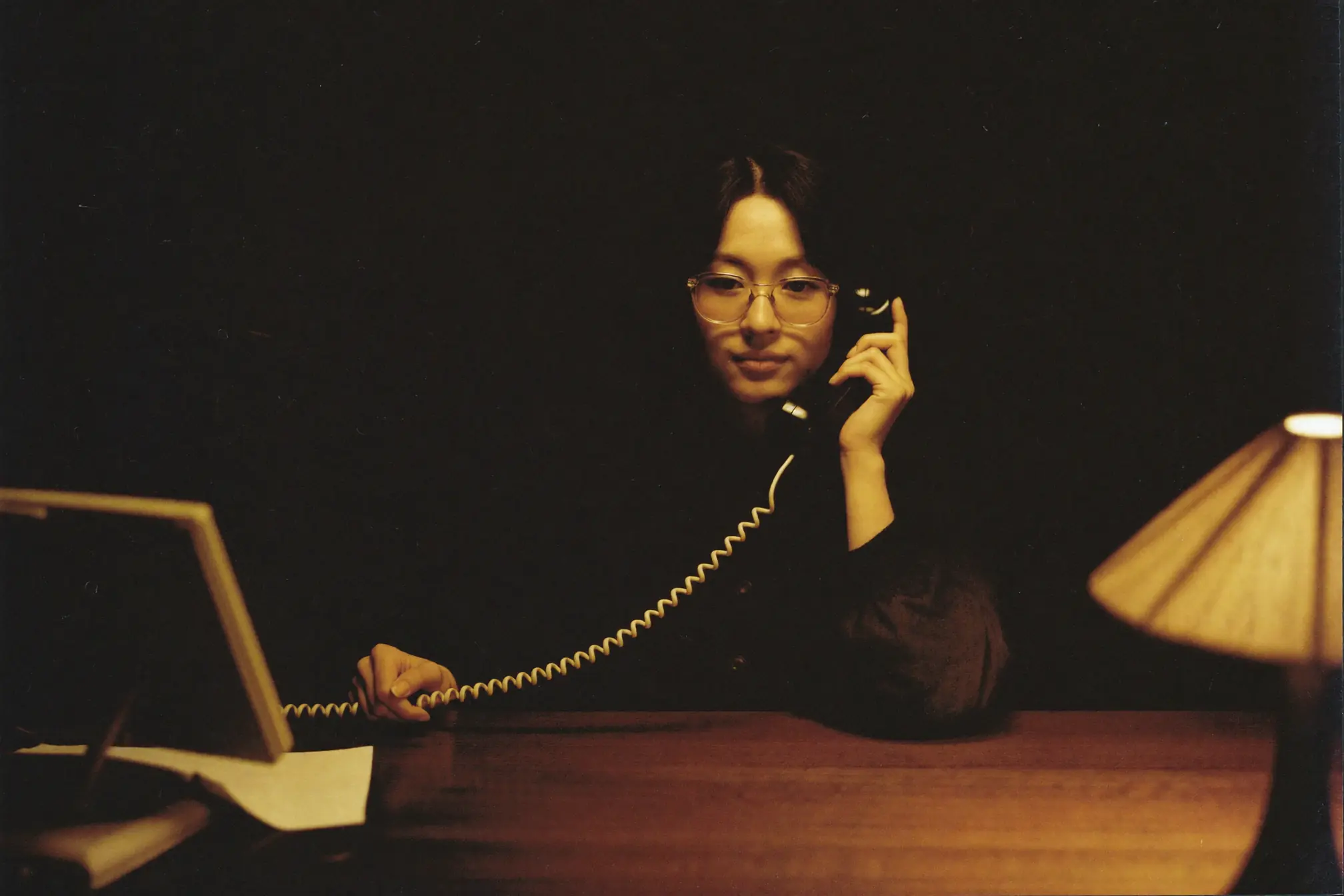 A receptionist holding a telephone receiver.
