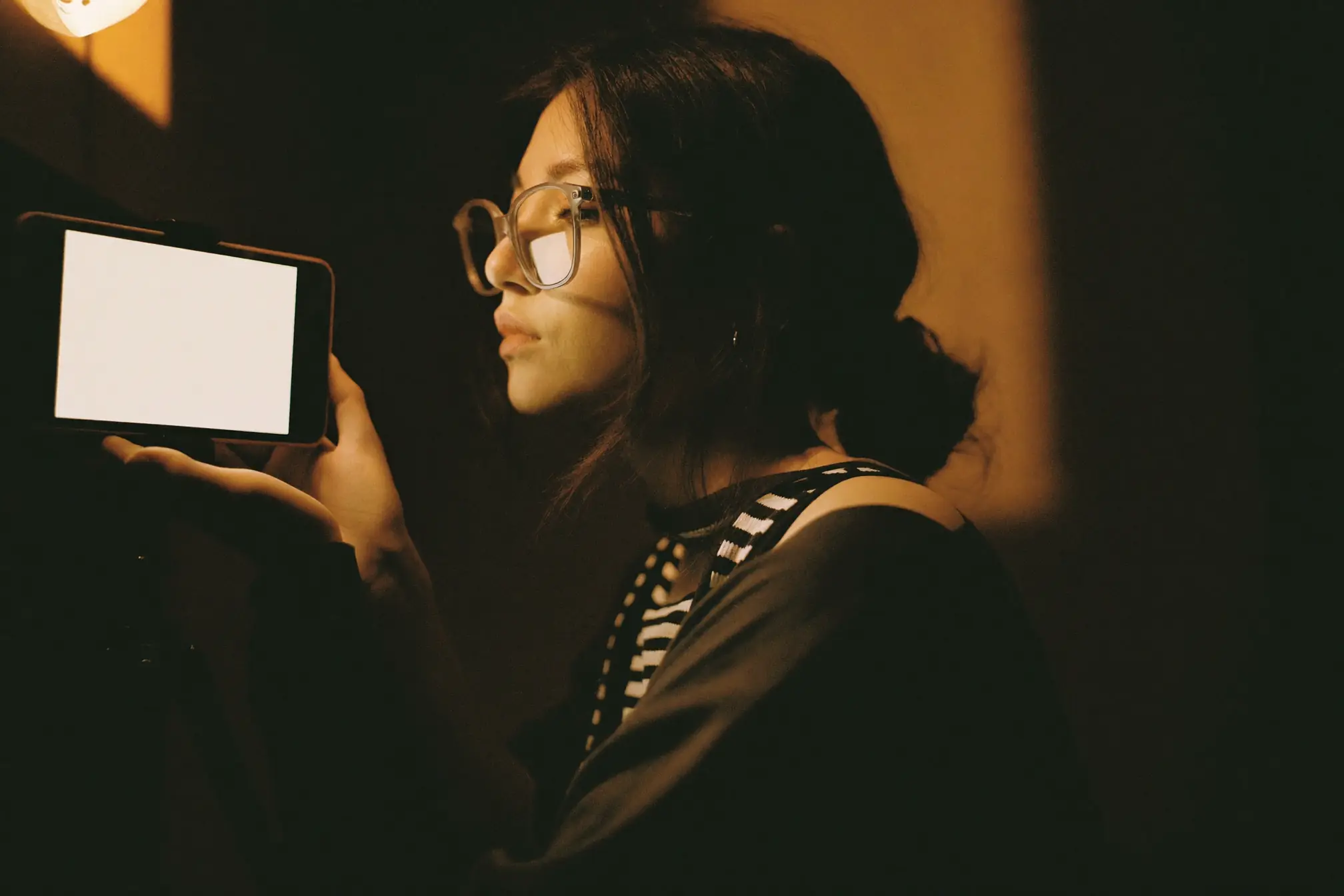 A content creator reviewing a phone on a small tripod.