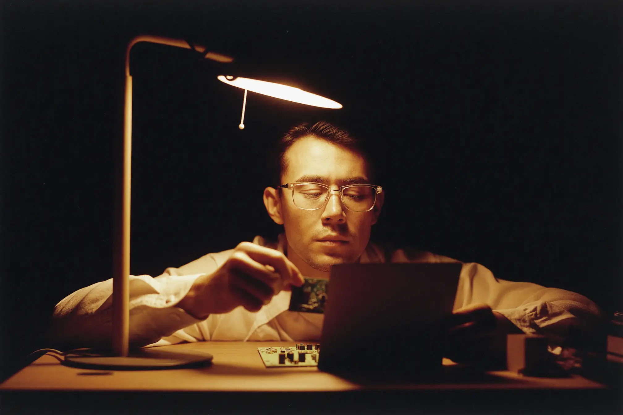 A repair technician holding a small circuit board close.