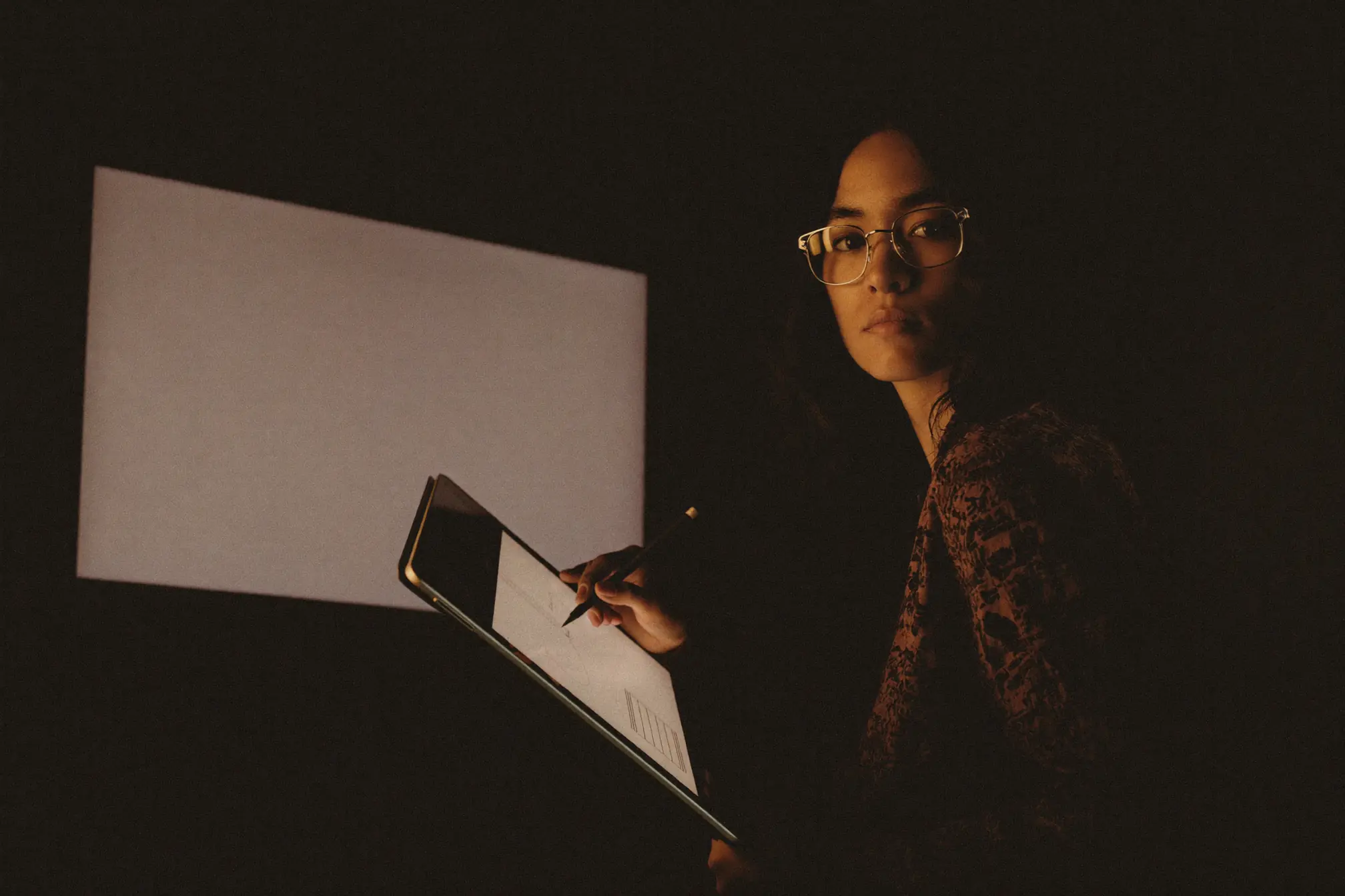 A visual effects artist drawing on a graphics tablet with a stylus.
