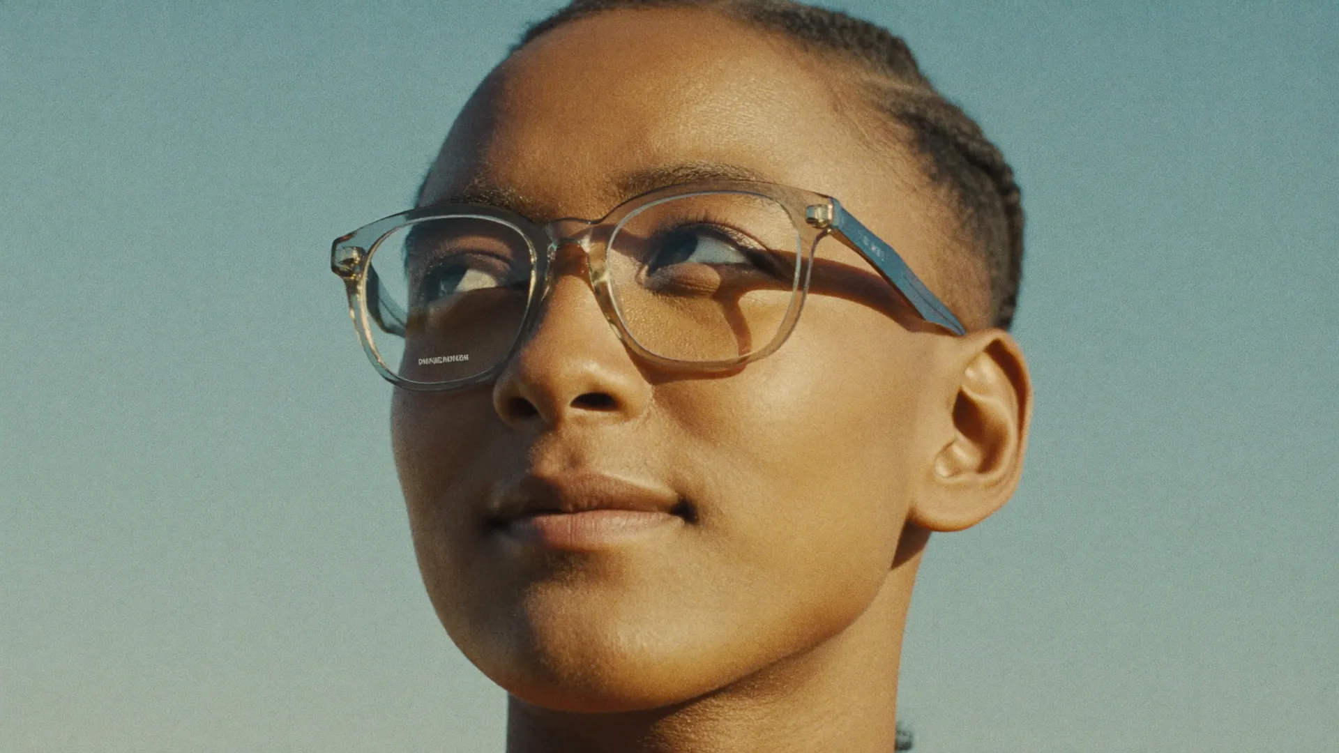 A wearer in bright daylight, sun on their face, looking toward the sky — the eye and ultraviolet.